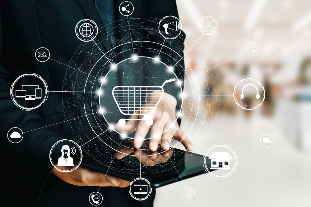 Phygital vs. Omnichannel Homem de terno segurando um tablet, com um holograma de um carrinho de compras e ícones de canais digitais e físicos, ilustrando o conceito de Phygital vs. Omnichannel.